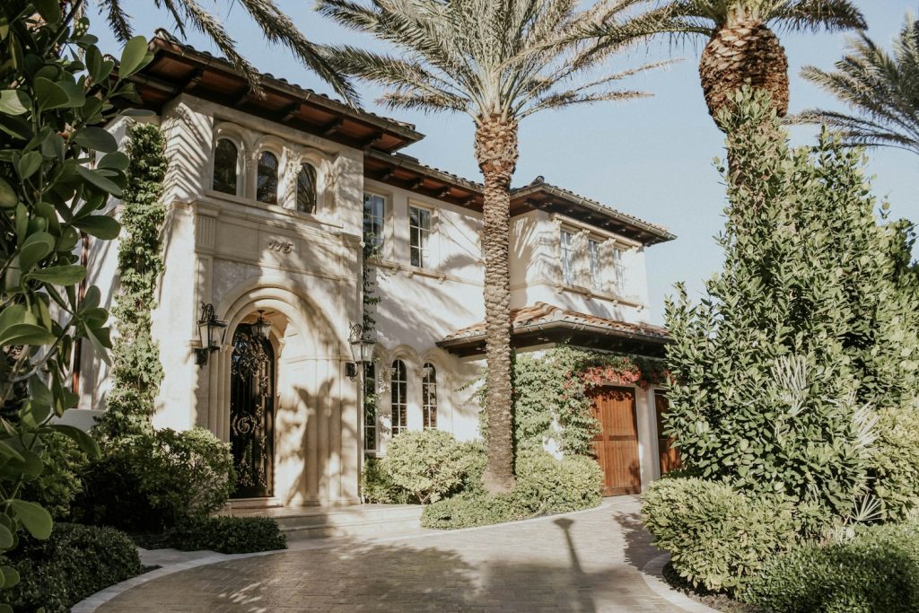 Mediterranean-style estate home with arched entry and palms