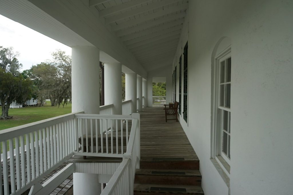 Long white front porch with columns and steps